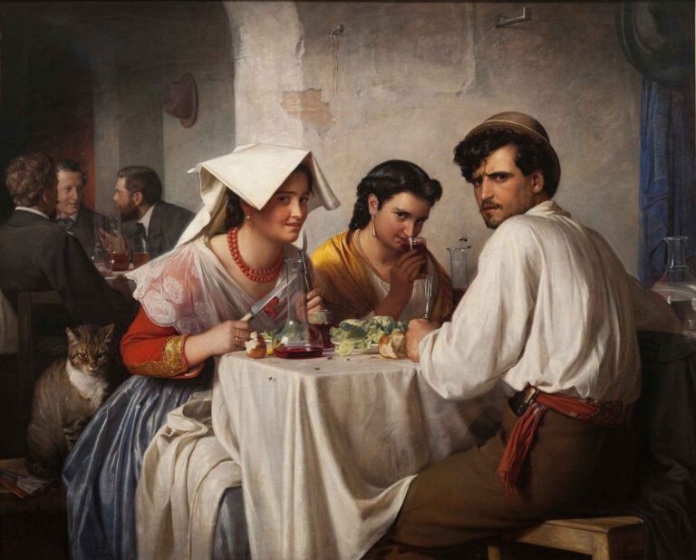 In an Italian tavern, two young women and a man sit at a round, white-clothed table with bread, wine, and vegetables; behind them, city-dressed men converse, while a cat watches from the side.