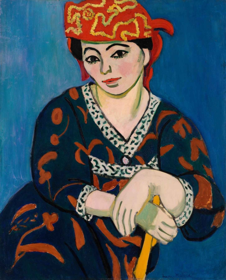 Portrait of a woman in a red madras headdress, painted by Henri Matisse with expressive brushstrokes and vivid Fauvist colors against a blue background.