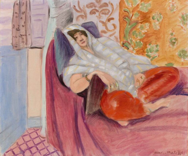 Woman Reclining by Henri Matisse (1921): a woman draped in a pale, patterned shawl reclines on a magenta chaise longue, wearing red trousers, set against an orange floral tapestry.