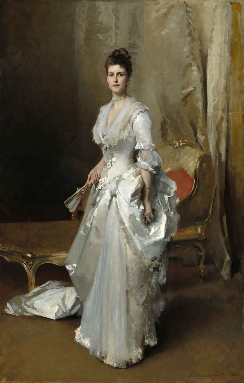 Full-length portrait of Margaret Stuyvesant Rutherfurd White by John Singer Sargent, showing a young woman in a white satin gown and bonnet holding a fan, standing beside a gilded fauteuil against a neutral drapery backdrop.