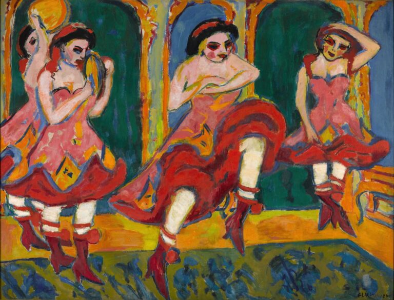 Four women in matching pink and red czárdás costumes kick and spin on a stage framed by deep green and blue arches; their swirling skirts, white stockings, and red boots flash under stage lights, capturing the rapid rhythm of Hungarian folk dance.