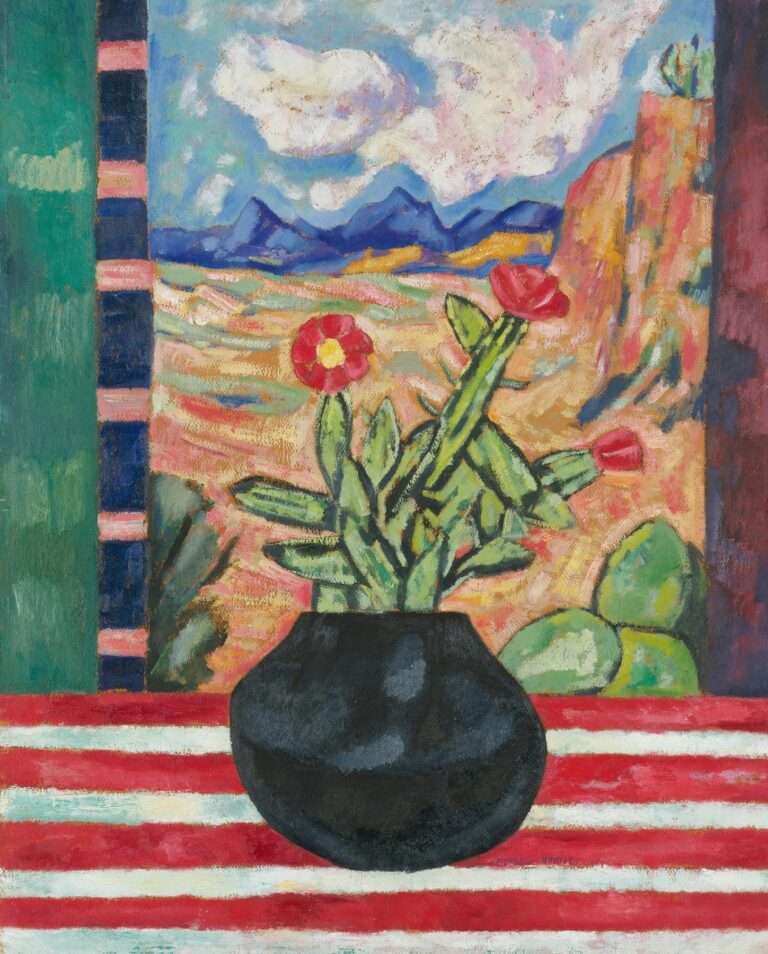 Marsden Hartley’s Still Life (1919), oil on canvas, showing a black pot with a flowering cactus on a red‑and‑white striped cloth, set before a window opening onto an ochre desert plain, blue mountains, and a cloud‑filled sky.