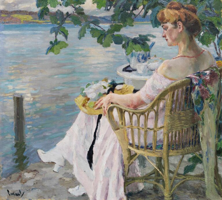 Woman in a pale pink gown seated in a wicker chair under leafy branches, reading beside a lakeside table with teacup and vase.
