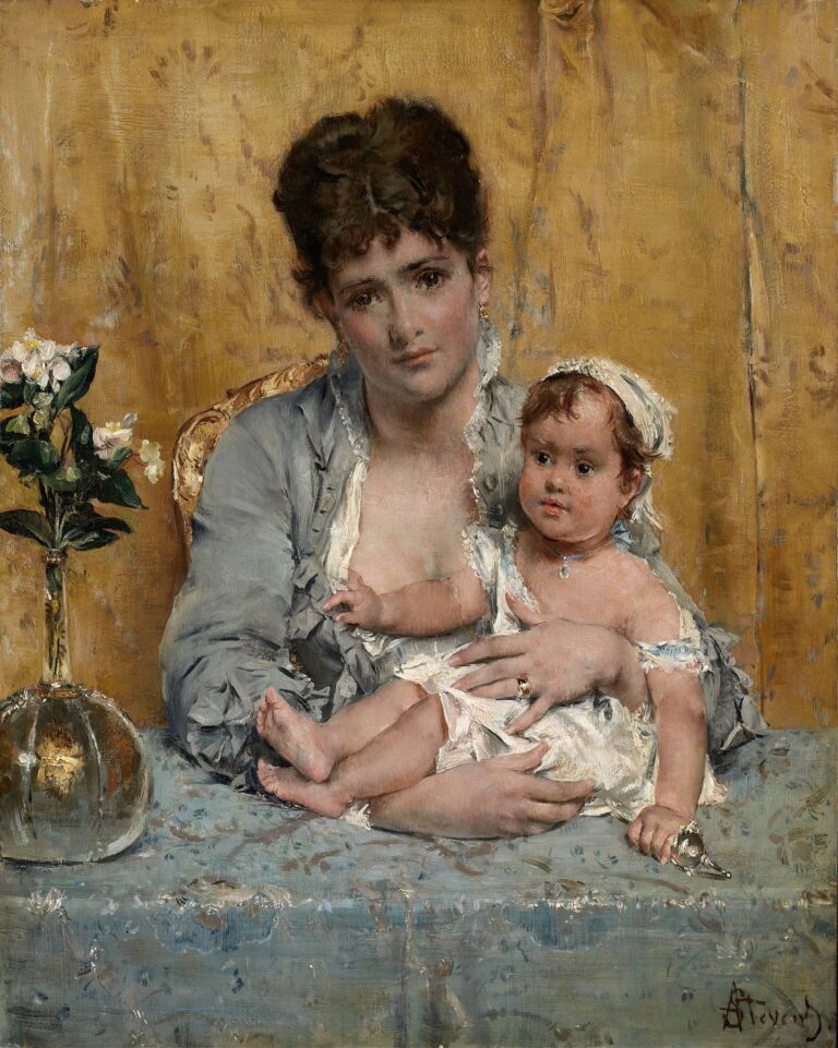 A young mother in a soft gray gown cradles her baby against a golden draped backdrop, seated beside a table with a vase of white blossoms, evoking tender maternal devotion.