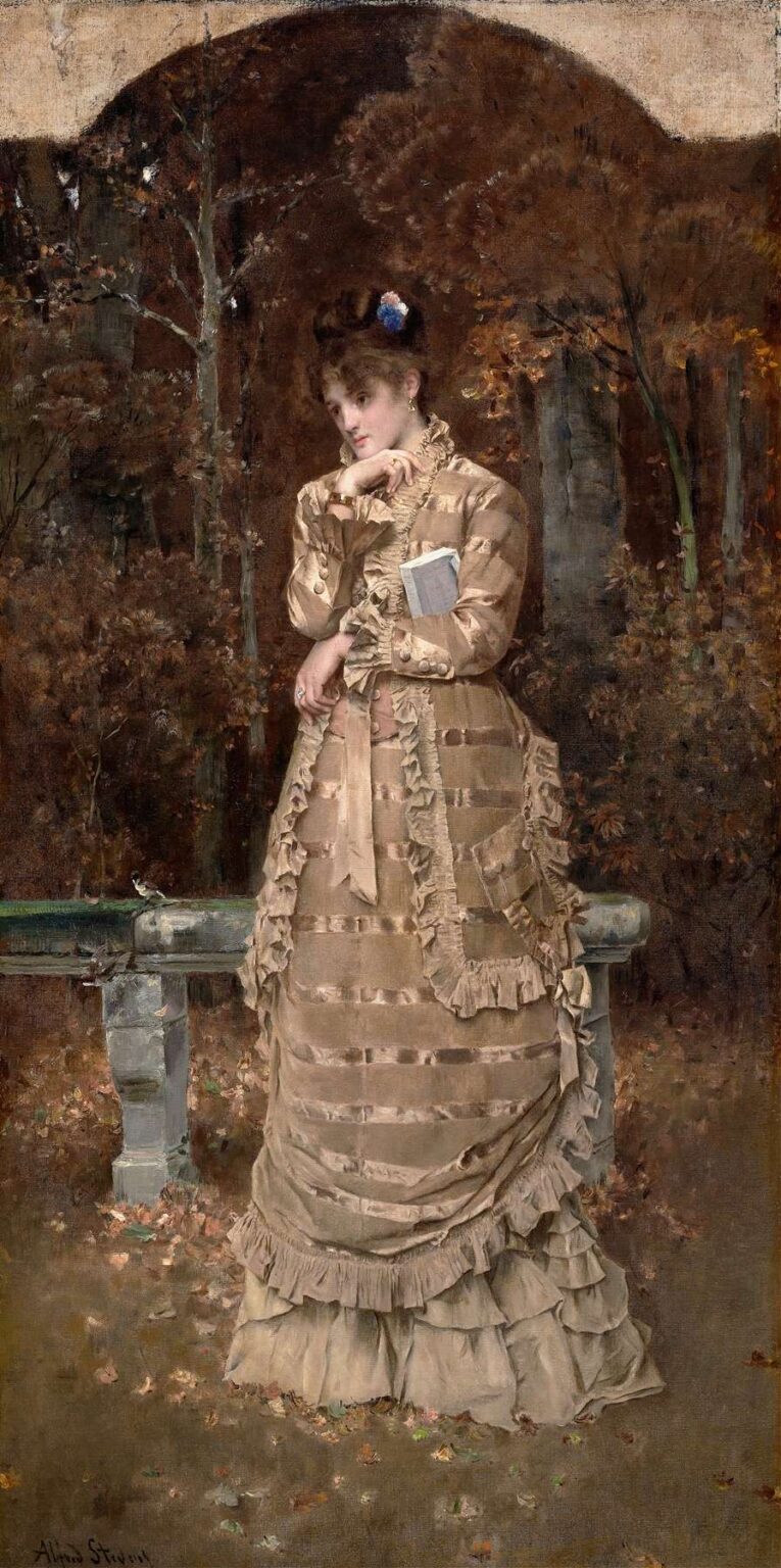 A finely dressed woman in a cream and taupe silk gown stands pensively beside a mossy stone bench in an autumn forest; fallen leaves cover the ground and tall, slender trees form a soft, brown‑ing canopy behind her.