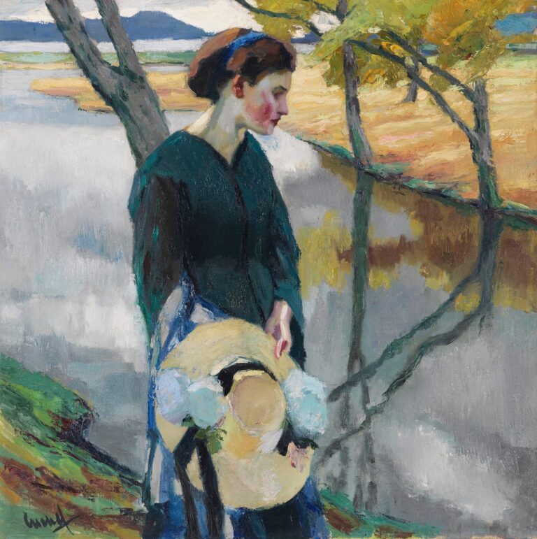 A young woman in dark green blouse and blue skirt stands on a riverbank holding a straw hat, with tree trunks and golden fields reflected in the water behind her.