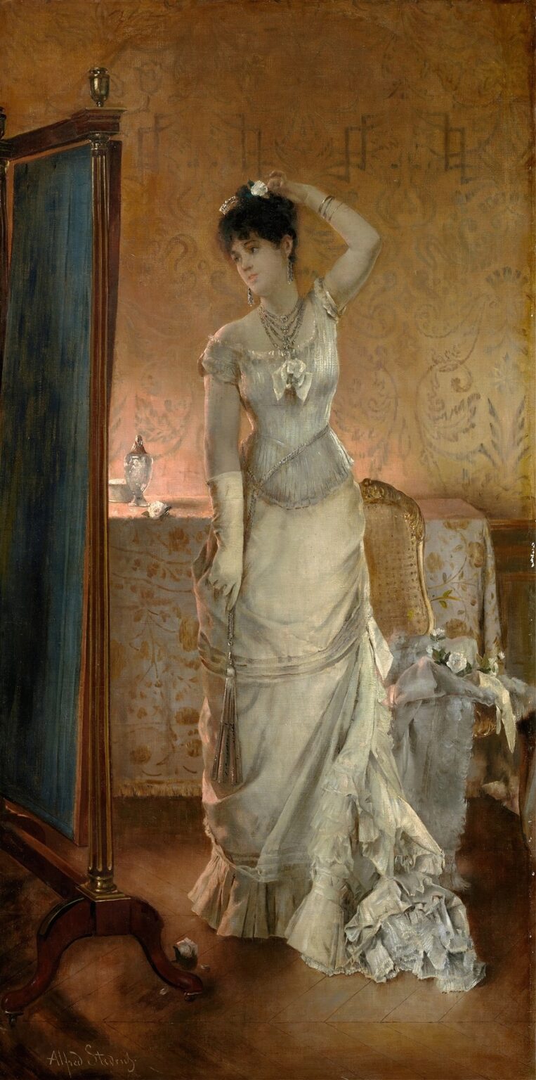 A woman in a high‑collared white silk dress trimmed with fur adjusts her hair before a tall mirror in a richly decorated interior illuminated by pale winter light.