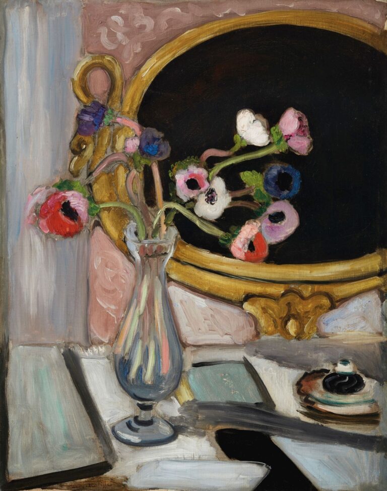 A slim glass vase of pink, red, white, and violet anemones sits on a pale gray-white tabletop beside a small cup and saucer. Behind it, a large oval mirror painted deep black within a gold frame reflects the flowers, set against a rose wall and a vertical blue-gray panel. Oil paint with visible strokes; made by Henri Matisse in 1919.
