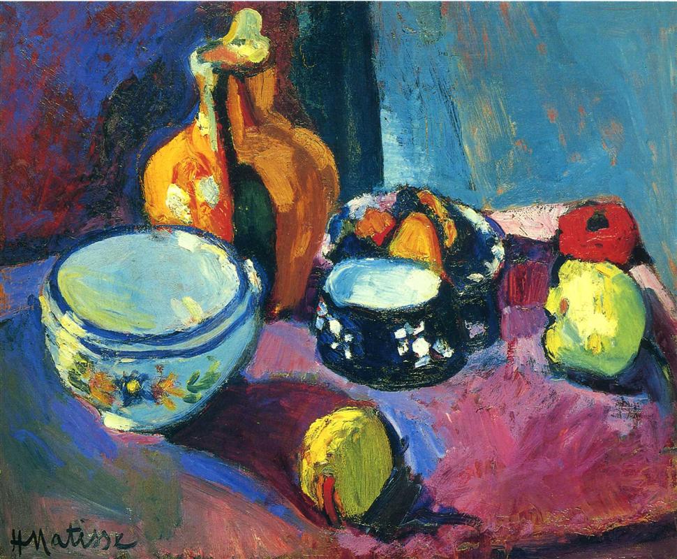 Tabletop still life on a magenta-red carpet with dark patches: large pale blue bowl at left, warm ocher pitcher behind it, black bowl with white motifs and fruit at center-right, lemon in front, red apple and green-yellow pear at right, against a cool blue wall painted in vivid, textured strokes.