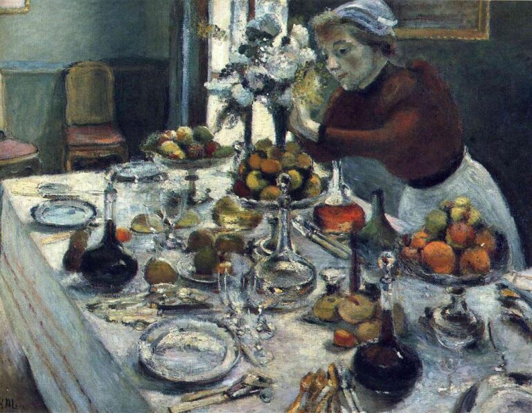 Interior dining room with a long white table set diagonally across the scene, covered in glass decanters, plates, cutlery, and bowls of fruit. At right, a woman in a dark red blouse and white apron leans in to arrange a tall bouquet near a sunlit window; cool green walls, empty chairs, and soft, pearly highlights create a calm, luminous atmosphere.