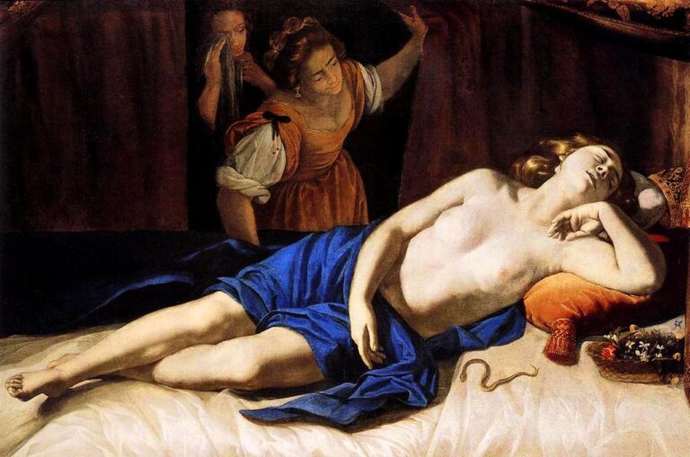 Cleopatra lies half-nude on a bed draped in blue, head on orange pillows, an asp coiled on the sheet as two attendants peek through a curtain; warm light models her slackening face and body within a dark, enclosed room.