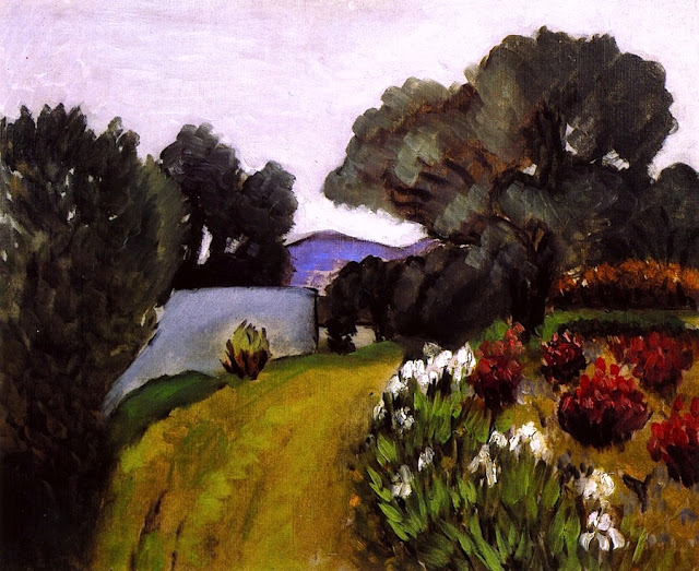 Sunlit garden with a curving green path beside a low white wall, large olive trees leaning over, and a right border of irises and red flowering shrubs; lavender hills and a pale sky recede beyond, painted with loose, vibrant strokes.