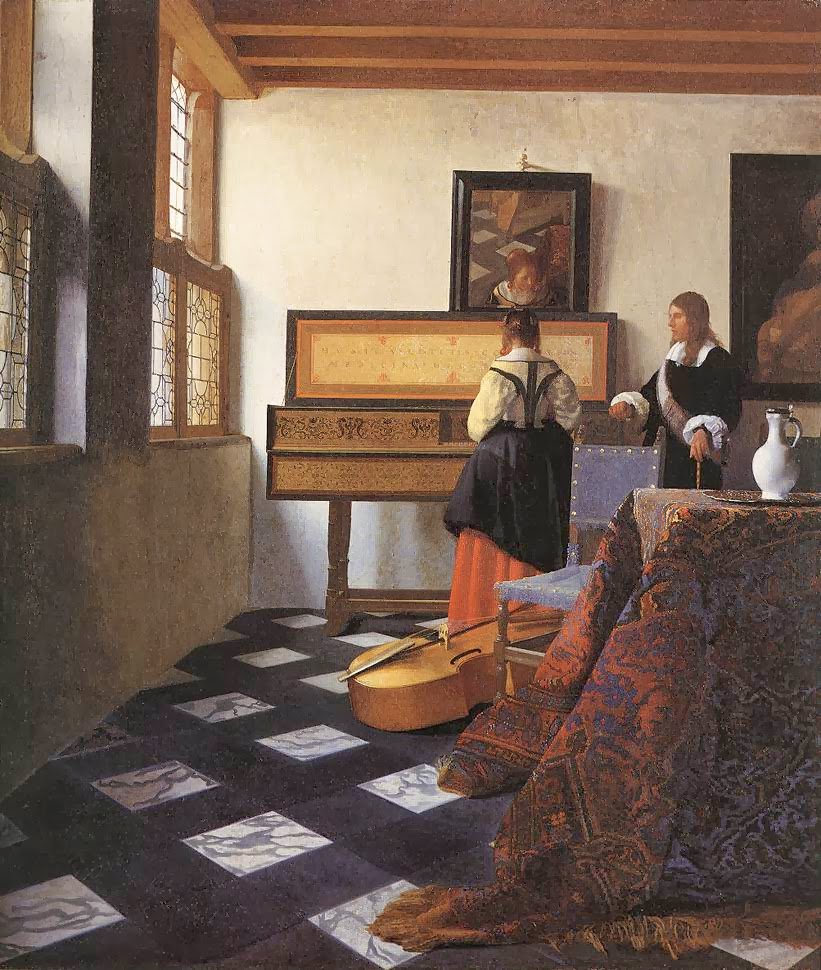 In a sunlit Delft interior, a woman stands at a decorated virginals while a gentleman in black watches; a viol rests on a tiled floor, an Oriental carpet drapes a foreground table, and leaded-glass windows illuminate paintings on the back wall.