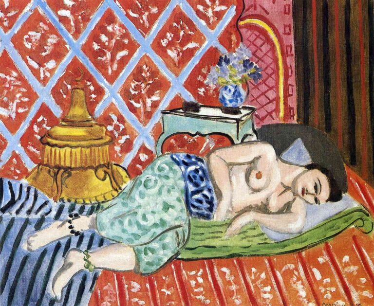Nude woman reclining diagonally on a green mattress with patterned wrap at the waist; background a terracotta wall of blue diamond lattice with white floral marks; gilt object at left, turquoise table with flowers at center, striped textiles below; Henri Matisse, 1927.