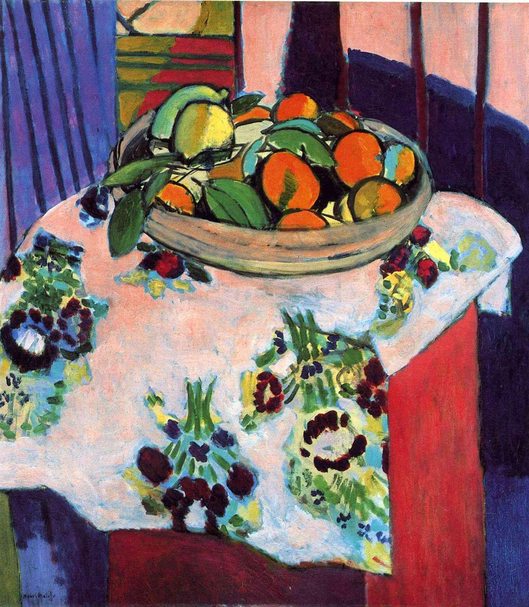 A 1913 still life by Henri Matisse showing a shallow bowl heaped with oranges, a lemon, and green leaves on a white floral tablecloth, with bold black contours and surrounding panels of pink, violet, and red that create a decorative, flattened space.