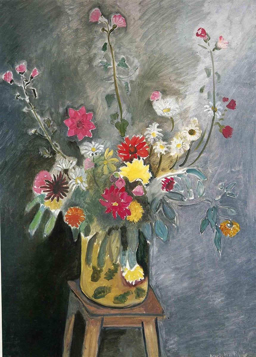A 1917 still life by Henri Matisse showing a yellow, leaf-decorated vase on a wooden stool filled with mixed flowers—red, pink, white, yellow, and orange—set against a swirling gray wall; strong dark contours, varied brushstrokes, and broad areas of cool tone create a balanced, modern arrangement.