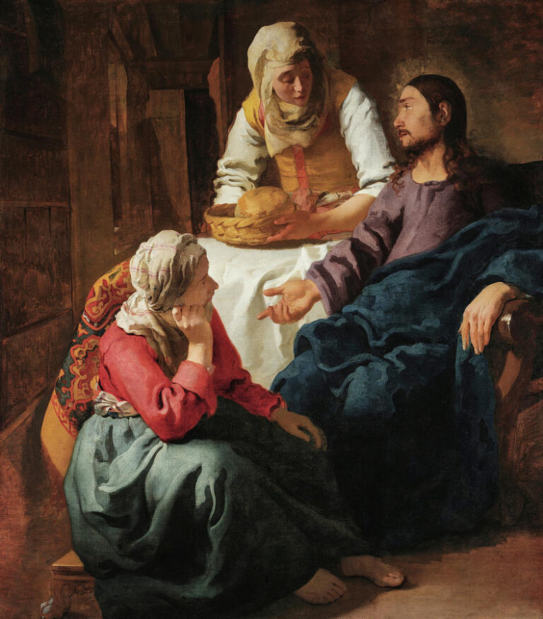 In a warmly lit interior, Christ sits at right draped in deep blue, teaching with an open hand as Mary listens at his feet in red and blue, while Martha stands behind a white-clothed table offering a basket of bread, all modeled with calm chiaroscuro.