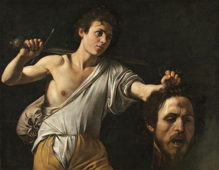 A bare-chested young David stands against a dark background, a sword resting across his shoulder as he holds Goliath’s severed head by the hair; sharp light models his skin and linen garment while the giant’s wounded forehead and slack features emerge from shadow.
