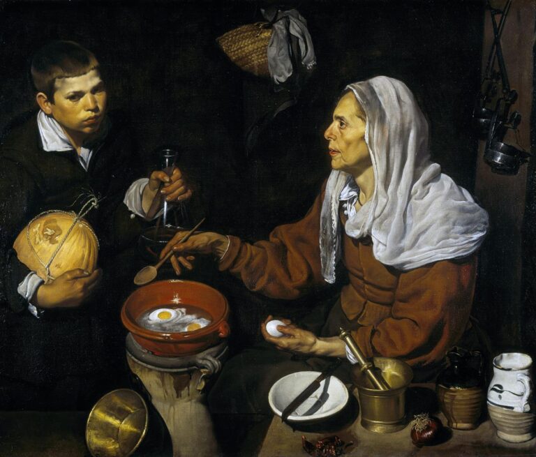 Elderly woman in a white headscarf fries eggs in a terracotta pan over a brazier while a boy holds a gourd and glass flask; brass mortar, white jug, onion, peppers, and other kitchen tools sit on a table against a dark background.