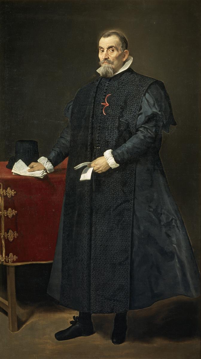 Full-length portrait of a Spanish magistrate in black robes standing beside a red-covered table, one hand resting on papers and the other holding a glove and folded note, with white collar and cuffs and a small red cross badge against a subdued dark background.