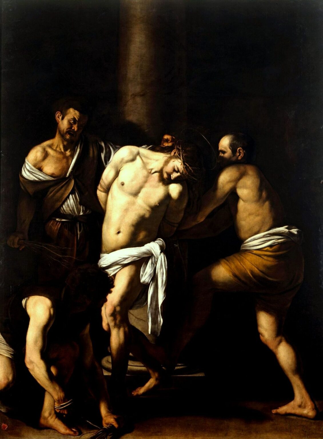In a dark interior, the bound Christ stands against a column with a faint halo and crown of thorns while three half-nude tormentors prepare and deliver blows; strong side light illuminates their muscular arms and Christ’s exposed torso as the background falls into deep shadow.