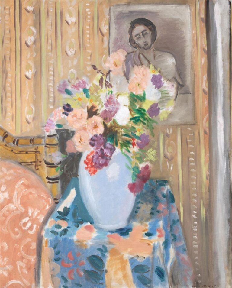 Large bouquet of multicolored flowers in a light oval vase on a blue patterned cloth, set before a warm ochre wallpaper and a grayscale portrait painting on the wall; a chair back appears at left; soft Mediterranean light and clear, harmonious color typical of Matisse’s Nice period.