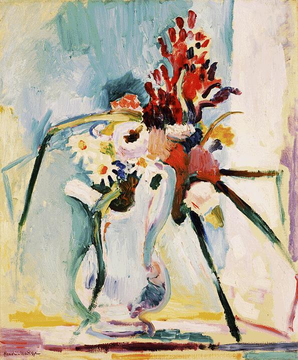 Still life painting of a pale white pitcher holding a bouquet with bright red spikes and soft white flowers; long green stems shoot diagonally across a cool blue-green wall, above a pale yellow-pink tabletop; loose, expressive brushstrokes and dark outlines characteristic of Matisse, 1908.