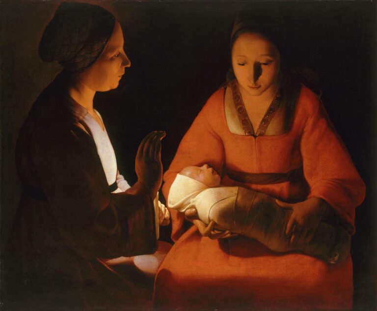 Candlelit scene of a mother in a red robe cradling a swaddled infant while a woman beside her raises a gentle hand; warm light seems to emanate from the baby, illuminating faces and hands against a dark background.