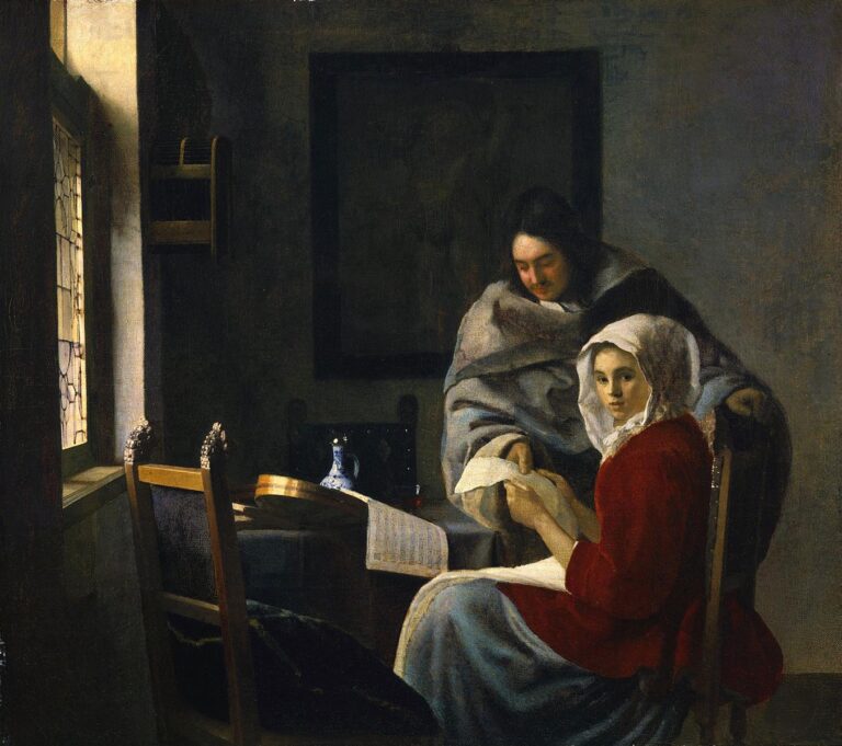 In a softly lit Delft room, a woman in a red jacket sits by a window holding a sheet of paper as a cloaked man leans over her shoulder; a cittern, music book, and blue-and-white jug rest on the table, and the scene feels suspended between music and conversation.