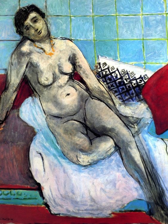 Reclining nude woman in a shallow room with turquoise tiled wall, white-blue bedding, two red cushions, and a small patterned pillow; flesh painted in cool grey-violet tones with subtle warm highlights; a slim red floor band at bottom; poised diagonal pose with head tilted toward viewer; Henri Matisse, 1929.