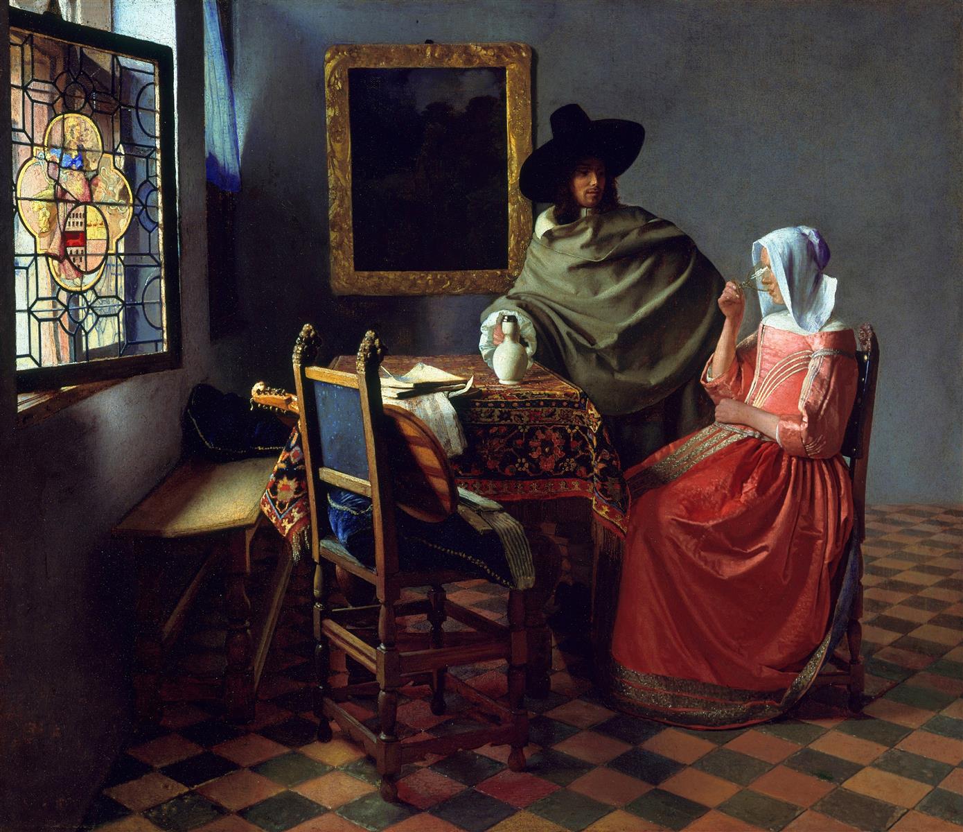 A woman in a red dress sits in a tiled room raising a wineglass as a man in a broad hat and olive cloak stands beside a carpeted table with a white jug, an open stained-glass window at left and a dark framed picture on the wall.