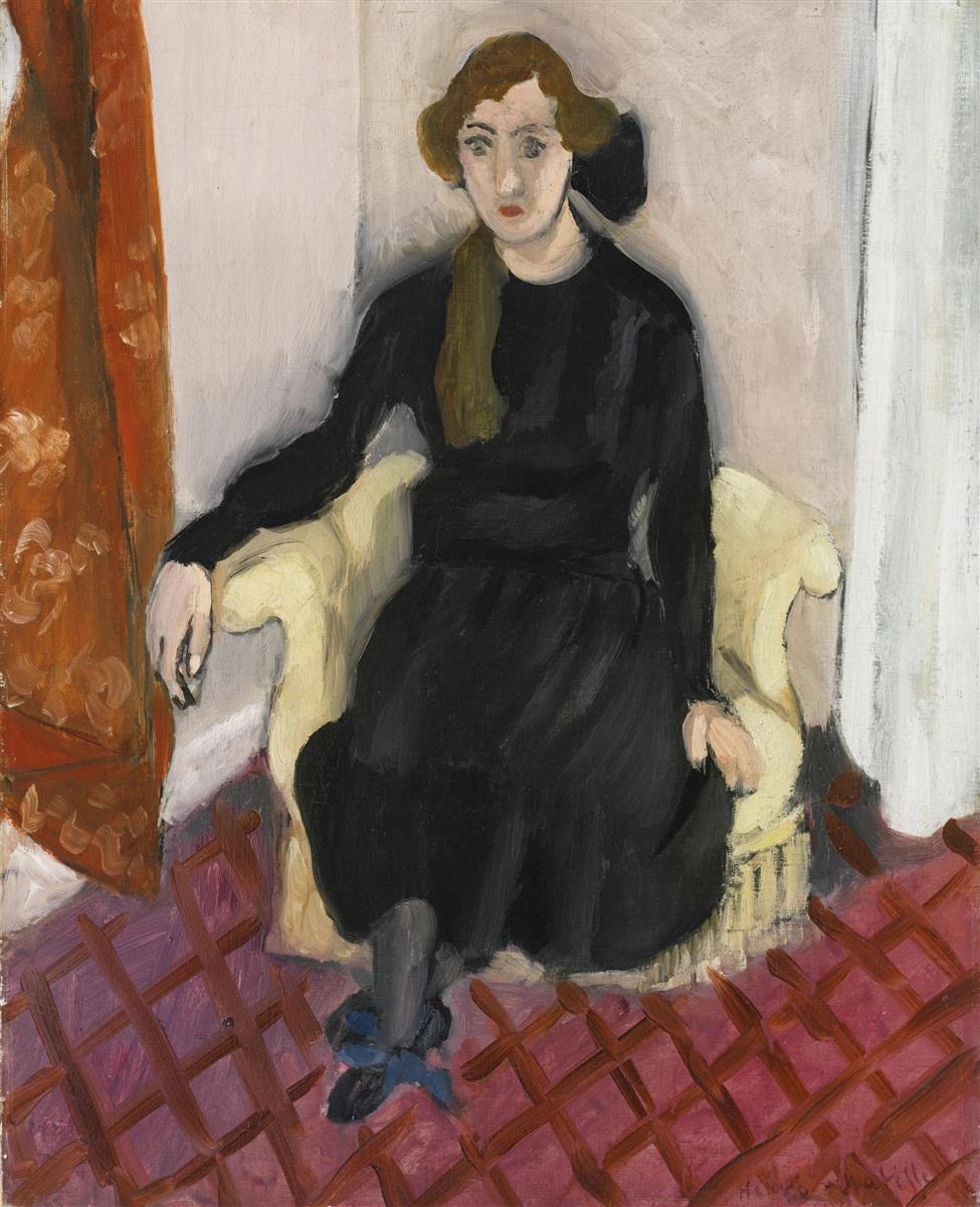 A young woman in a black dress sits in a pale armchair on a pink floor with a russet diagonal grid; an orange curtain frames the left side and a light wall the right, in a painting by Henri Matisse.
