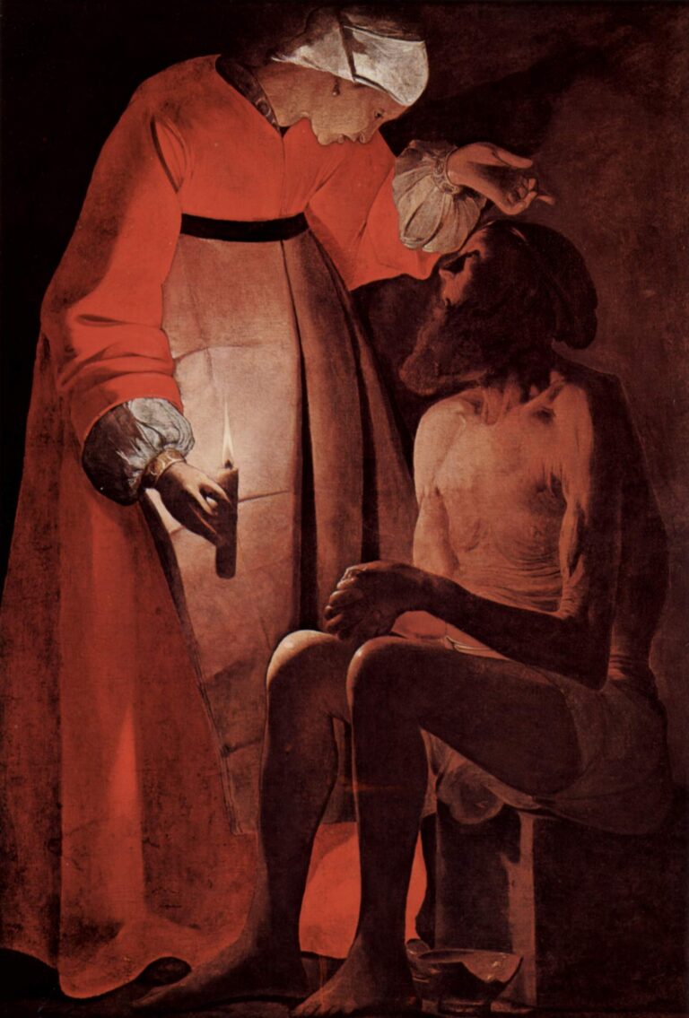 Night scene of Job seated nearly naked on a low block while his wife, in a red robe and white headscarf, bends over him holding a small candle; her raised hand gestures above his head as the warm light models their faces and casts deep shadows in a sparse interior.