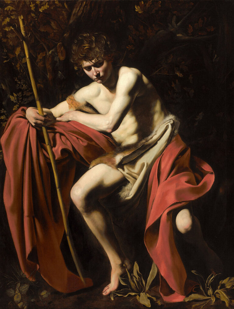 A youthful John the Baptist sits in a dark woodland, bare-chested with a red mantle draped around him, lightly holding a reed staff as a raking light models his body; one knee lifts, head tilts down, and broad leaves gather at his bare feet.