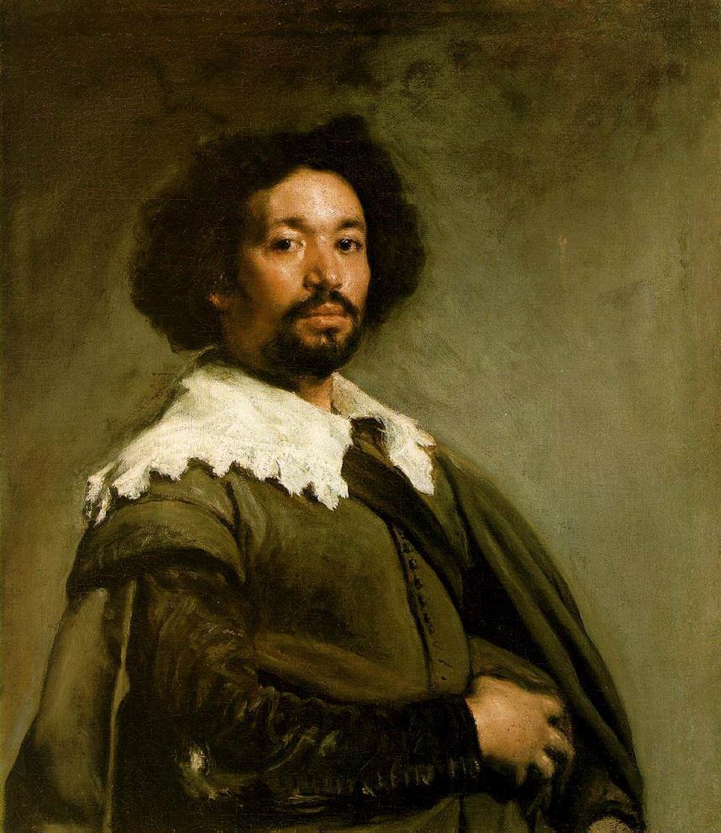 Half-length portrait of Juan de Pareja wearing an earthy green-brown doublet and draped cloak with a ragged white collar, turned three-quarters with a steady gaze against a soft gray-green atmospheric background.