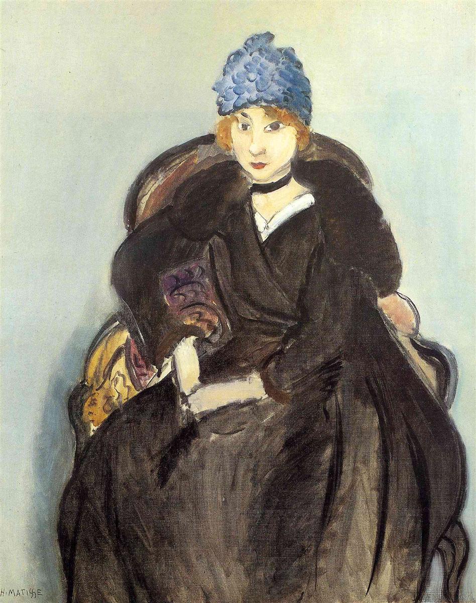 Seated portrait of Marguerite Matisse wearing a textured blue hat and black dress in an upholstered armchair, pale blue-gray background, small white collar and black choker; simplified forms, visible brushwork, and tuned warm–cool contrasts typical of Matisse in 1918.
