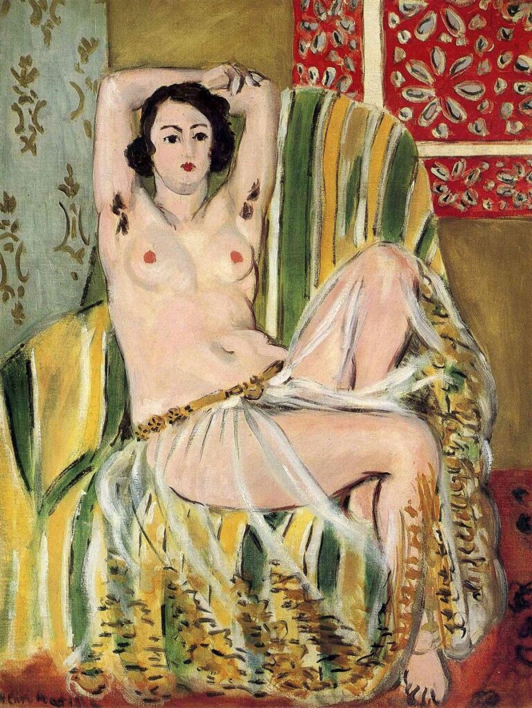 A nude woman reclines on a striped yellow-green armchair with her arms raised behind her head; a transparent gold-trimmed sash drapes her hips while patterned olive wallpaper and a red Moorish screen surround her in a richly decorative interior.