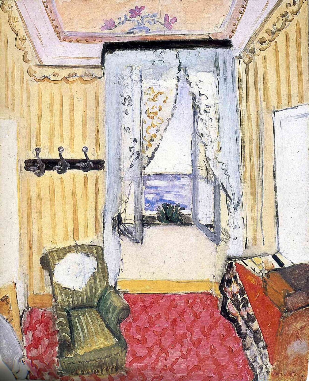Small hotel room with red patterned carpet, yellow striped walls, green armchair, bed with draped coverlet, and an open window framed by lace curtains revealing a blue sea; pink ceiling medallion and black curtain rod; simplified forms and airy color typical of Matisse in 1918.