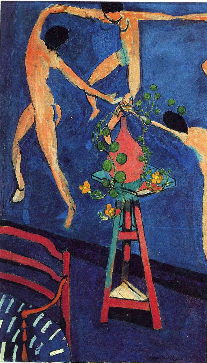 A vertical Matisse painting from 1912 showing a red vase with trailing green nasturtiums on a trestle table in the foreground, a striped red chair and rug at lower left, and cropped nude dancers from “The Dance” swirling across a deep blue wall behind, all rendered in flat, saturated color with bold contours.