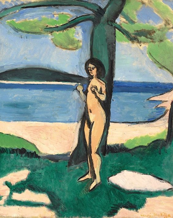 A simplified nude stands beside a pine on a Mediterranean shore; bands of blue sea and sky meet pale sand and green turf, with bold dark contours and broad color planes organizing the scene in Matisse’s 1909 “Naked by the Sea.”