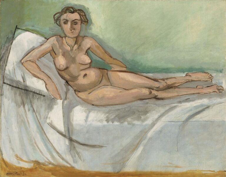 A reclining nude by Henri Matisse (1918) shown diagonally across a white bed against a pale green wall; warm flesh modeled by broad planes and dark contours, with visible brushstrokes and a small ochre floor strip grounding the composition.