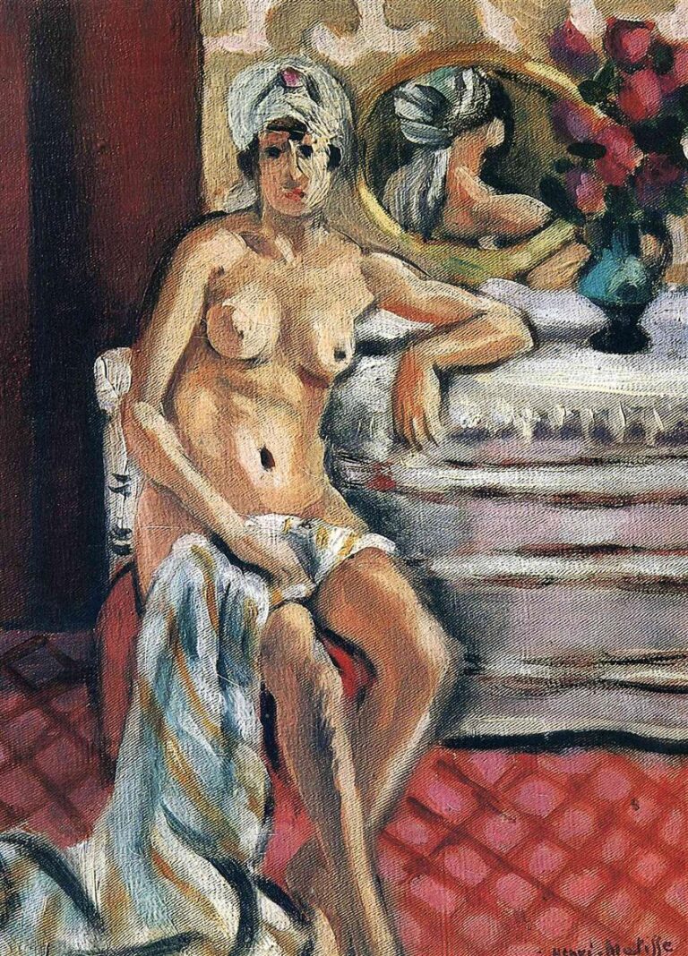 Seated nude woman wearing a white turban with a pink jewel, resting beside a white dressing table with an oval mirror and vase of flowers; red tiled floor, patterned beige wall, and a striped drapery across her lap; soft, even Nice-period light and clear, balanced color planes.