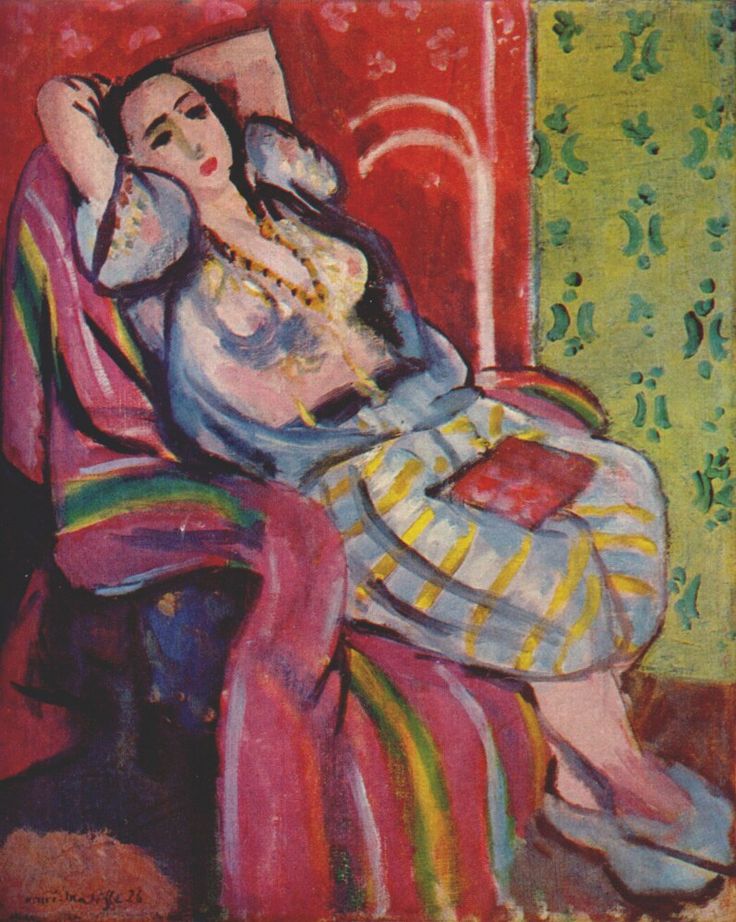 Reclining woman with arms raised in a patterned interior: crimson wall with motifs at left, green panel at right, violet shawl with rainbow stripes over the chair, gray-and-yellow striped skirt, sheer blouse, and a red book on her lap; painted by Henri Matisse in 1926.