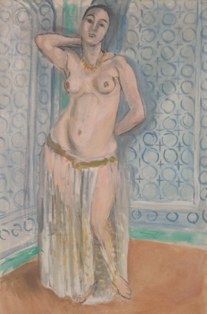 Standing semi-nude woman with necklace and light skirt in a corner room; blue walls patterned with circular latticework, teal baseboard, and warm terracotta floor; one arm raised behind the head, feet crossed, soft Mediterranean light and gentle colors typical of Matisse’s Nice period.