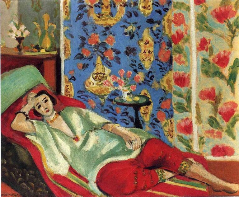 Reclining woman on a low daybed wearing ornate red trousers and a pale green blouse, set before a blue patterned hanging with flowers and gold medallions, a small round table with bouquet beside her, painted in Matisse’s vibrant Nice-period style.