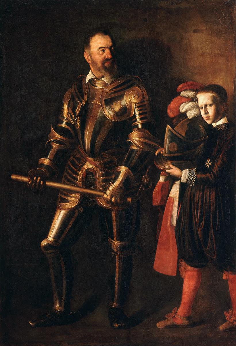A life-size portrait shows the Grand Master Alof de Wignacourt in gleaming armor holding a baton of command while a young page at his side presents a plumed helmet; both figures emerge from a dark background under focused light, with the boy’s sleeve bearing the small cross of the Order of Saint John.