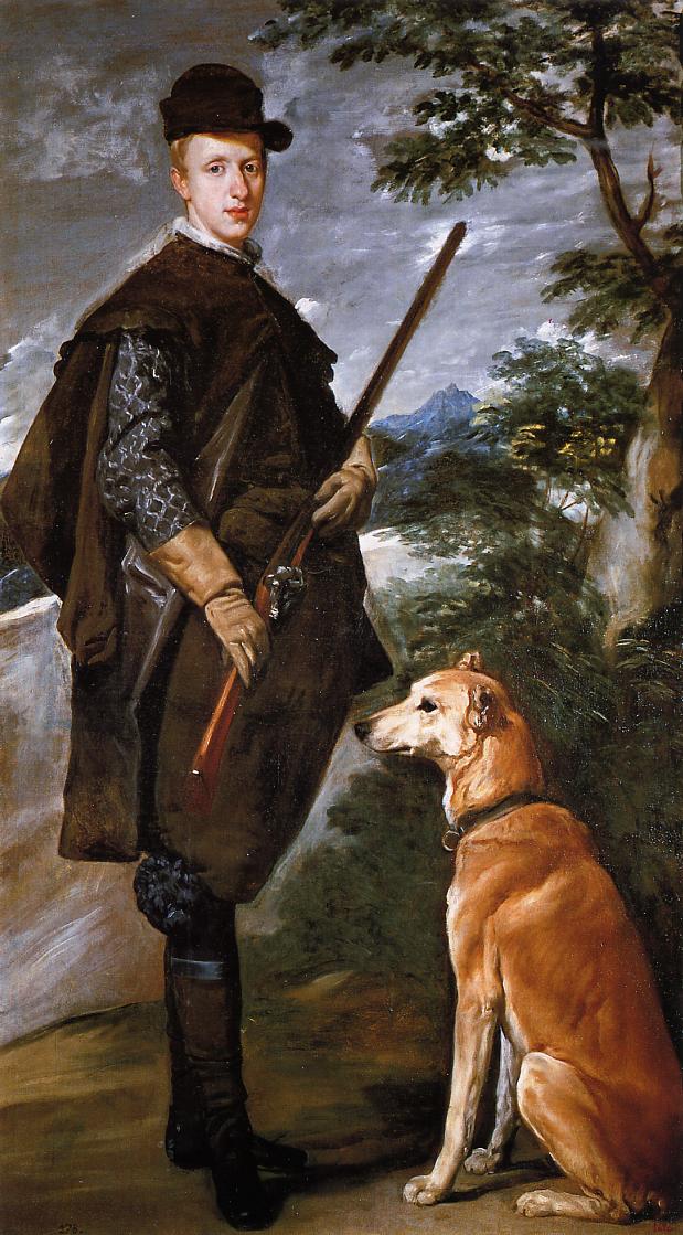 Full-length outdoor portrait of a young royal in brown hunting cape and hat holding a firearm on a rocky path, with a seated greyhound at his side, trees framing the scene and mountains receding under a cool, clouded sky.