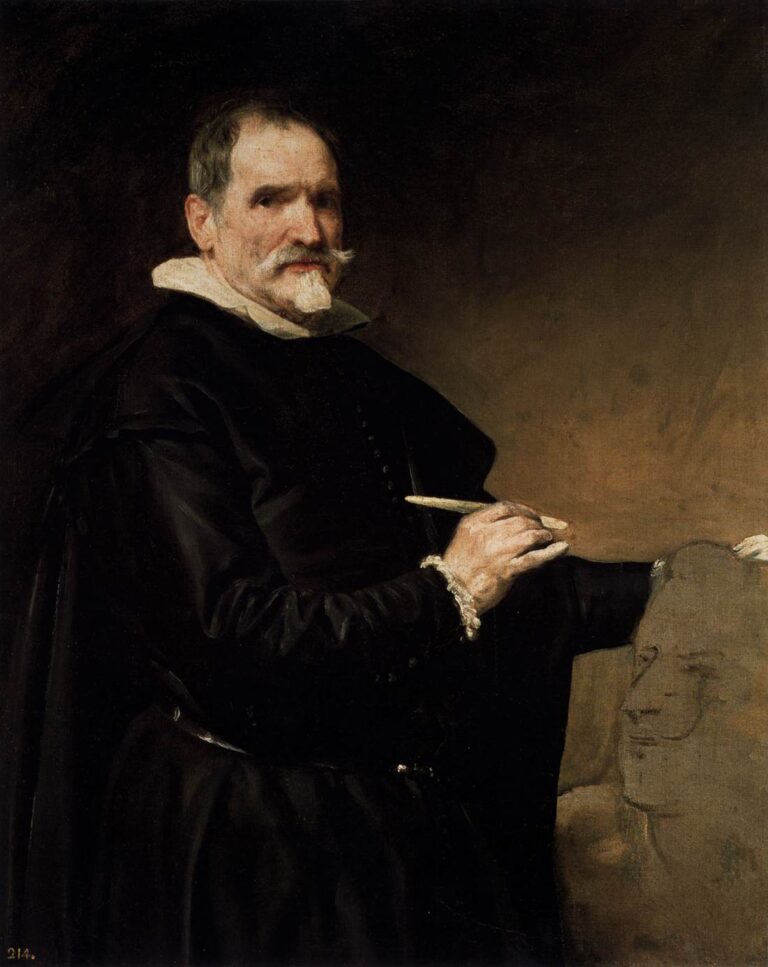 Three-quarter portrait of sculptor Juan Martínez Montañés in black attire with white collar, holding a modeling tool as he works on a clay head; his illuminated hand and thoughtful gaze stand out against a warm brown studio background.