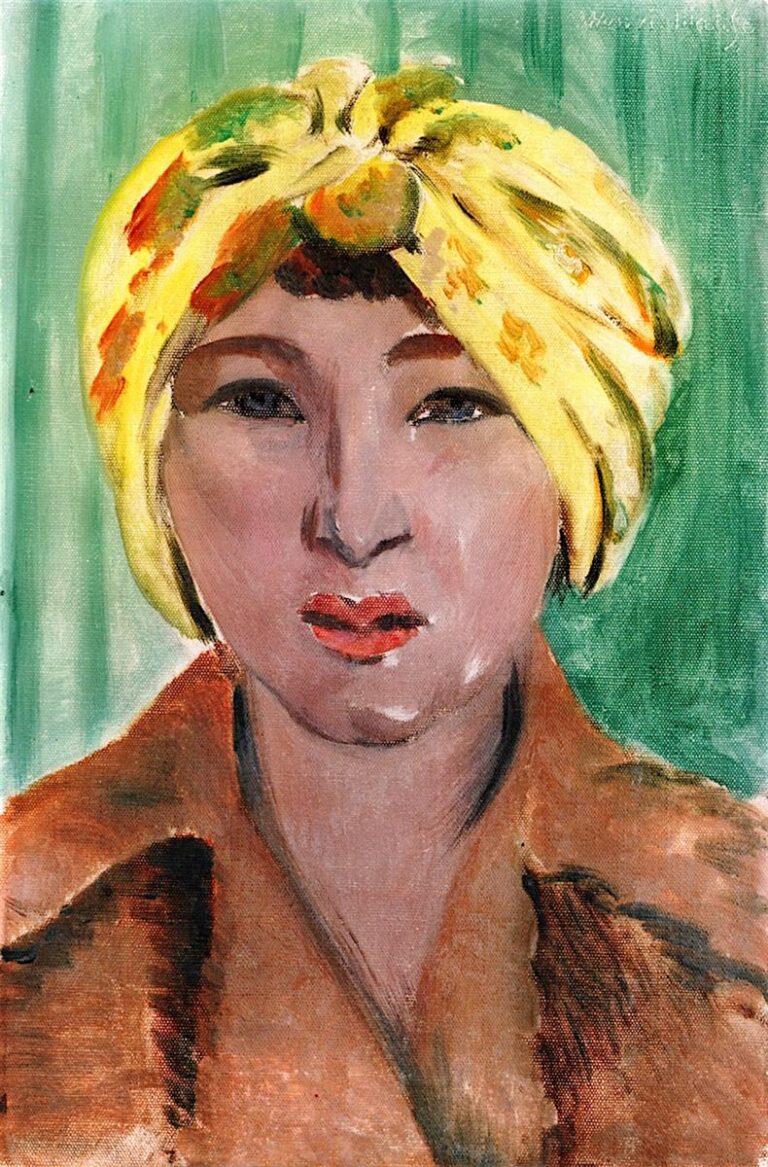 Frontal head-and-shoulders portrait of a woman wearing a bright yellow patterned turban and a brown coat, set against a cool green background; simplified features, coral lips, and visible brushstrokes exemplify Matisse’s Nice-period style.