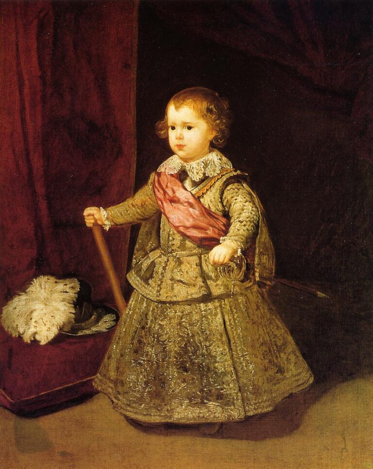 A small boy in ornate gold brocade with a pink sash stands before a red curtain, holding a baton and touching a tiny sword; a large plumed hat rests on a cushioned stool beside him.